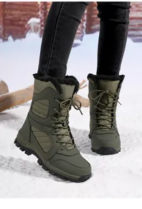 Detail view of olive green lace-up snow boots with plush faux fur lining on snow.