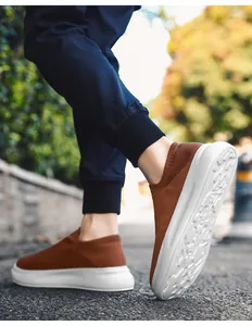 Close-up of brown fly-knit slip-on sneakers for men in an outdoor walking scene