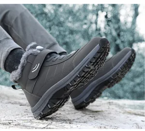Close-up of grey fleece-lined high-top winter walking boots displayed on snow