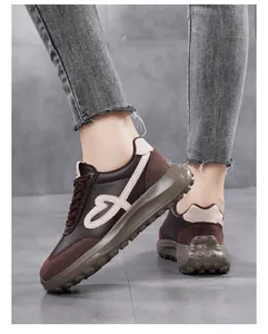 Close-up of brown platform sneakers with heart embroidery and textured thick sole.