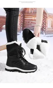 Detailed view of women's warm black snow boots with thick white faux fur lining details