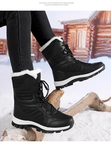 Detail of women's black lace-up snow boots with faux fur lining on a snowy outdoor background