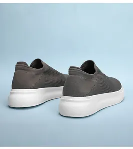 Detailed rear view of breathable grey fly-knit slip-on sneakers for men with chunky white soles