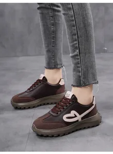 Close-up detail of vintage brown platform sneakers featuring heart embroidery on side