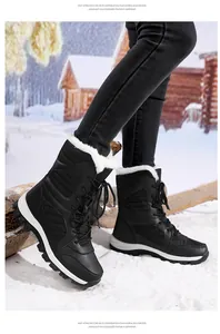 Detailed view of women's warm black snow boots with white fur lining on a snowy ground