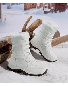 Detailed view of white high-top fur-lined snow boots in a snowy outdoor winter setting