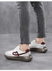 Detailed side view of women's thick-sole casual sneakers with heart embroidery