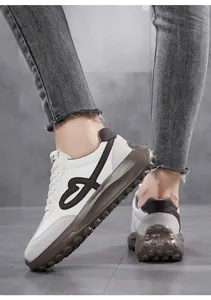 Detailed view of vintage heart embroidery on stylish white platform sneakers for women.