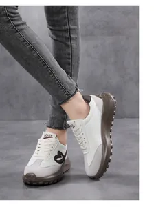 Detailed side view of retro beige sneakers with heart embroidery and chunky brown soles