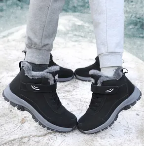 Detailed shot of black fleece-lined high-top snow boots worn on feet in winter outdoor