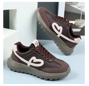 Detailed view of brown platform sneakers featuring heart embroidery and rugged rubber sole