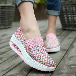 Atmungsaktive rosa gewebte Rocker-Laufschuhe für Damen auf rustikalem Holzboden