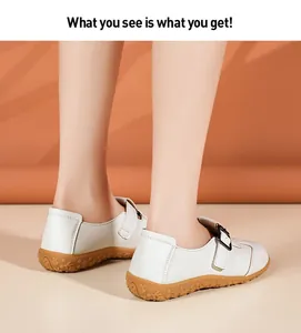 Detailansicht von weißen Retro-Loafern mit flacher Sohle an den Füßen des Models
