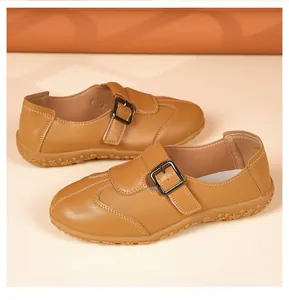 Detailansicht der retro braunen flachen Lederschuhe mit verstellbarer Schnalle und weicher Sohle.