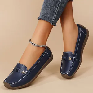 Close-up of navy blue soft-sole loafers on feet, casual flat slip-on women's shoes.