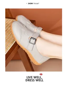 Graue Retro-Mary-Jane-Flats mit verstellbarem Schnallenriemen, am Fuß in Lifestyle-Umgebung.