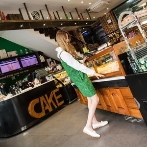Close-up of white leather loafers worn by a model in a stylish bakery lifestyle setting