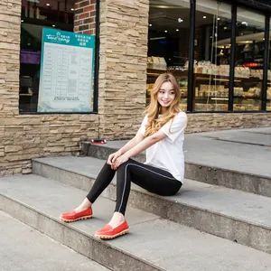 Stylish red leather flat loafers for women worn in a casual outdoor urban setting
