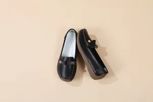 Detailed top view of black women's loafers with metallic buckles and brown textured soles