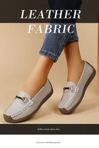 Close-up of grey leather loafers with elegant metal buckle on a casual model wearing jeans