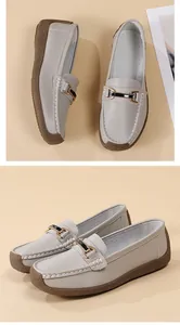 Detail view of light grey women's loafers with metal buckle and white stitching