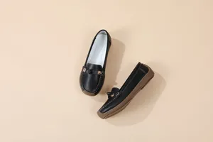 Detailed view of comfortable black soft-sole moccasins with elegant metal buckle decoration