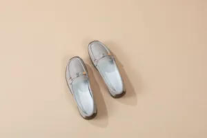 Detailed view of grey soft sole moccasins with metal buckle and slip-on design