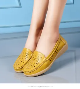 Detail of yellow perforated leather loafers with comfortable wedge sole for women