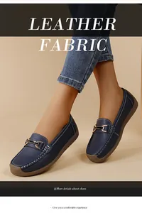 Detailed view of dark blue leather loafers with elegant gold buckle and stitching