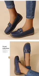 Close-up of navy blue women's loafers with metal buckle and white stitching details