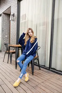 Stylish yellow cowhide flat loafers for women styled with jeans in an outdoor cafe