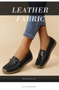 Close-up of black loafers with metal buckle on model's feet