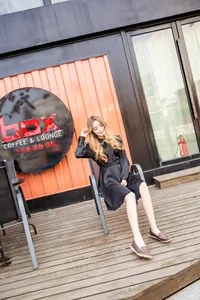 Full body view of a woman wearing brown leather loafers in an outdoor cafe setting
