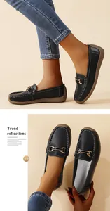 Detail of black leather loafers for women with decorative gold buckle and soft sole