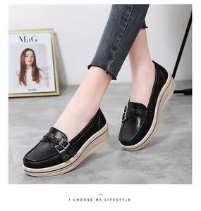 Detailed view of stylish black platform wedge loafers with buckle and beige sole