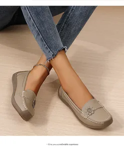 Gedetailleerd beeld van beige damesloafers met een zachte zool en een bloemaccent.