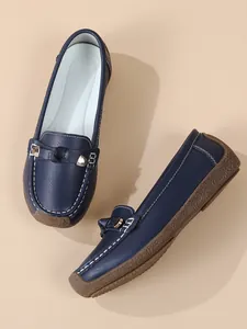 Detail view of navy blue soft-soled loafers with textured non-slip rubber soles