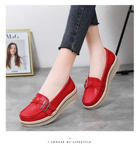 Detailed view of red platform wedge loafers featuring elegant decorative metal buckles