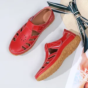 Vue détaillée de sandales plates rouges en cuir avec motif à fleurs et semelle antidérapante