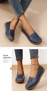 Detailweergave van marineblauwe loafers voor dames met bloemapplicatie en contraststiksel