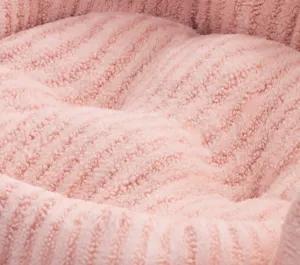 Close-up of pink plush dog bed featuring 2-hole positioning to prevent filling shift.