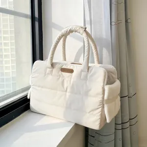 Cream white quilted pet carrier bag for cats and dogs placed on a sunny bright windowsill