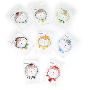 Detailed view of eight colorful pet collars with cartoon charms and bells in packaging