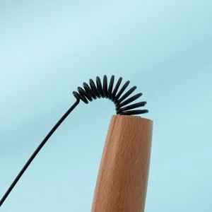 Close-up macro view of the flexible black wire and smooth wooden handle of a cat teaser wand