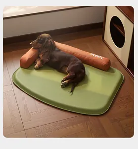 Comfortable dog lying on a waterproof green pet mat with an orange bolster support pillow.