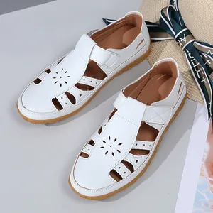 Vue détaillée de sandales de plage blanches en cuir ajouré pour femmes avec fleurs