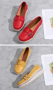 Close-up detail view of red and yellow platform loafers with decorative metal buckle strap.