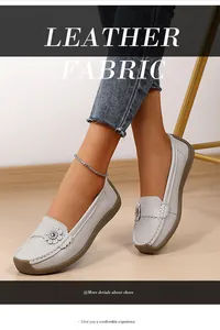 Detailweergave van comfortabele grijze leren loafers voor dames met stijlvol bloemornament.
