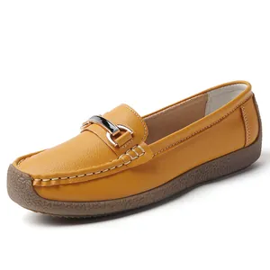 Comfortable yellow leather loafers for women with soft sole and metal buckle detail.