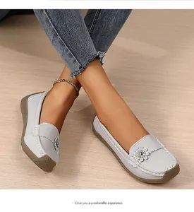 Detailopname van comfortabele grijze damesloafers met een sierbloem en een zachte zool.